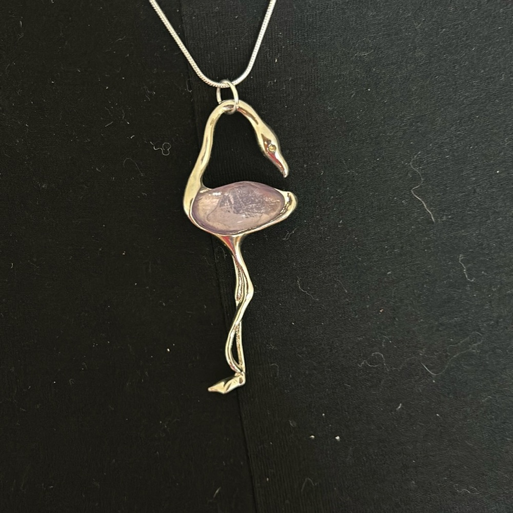 Silver crane necklace/brooch with light purple stone.